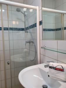 科隆Hotel Arena的带淋浴和白色盥洗盆的浴室