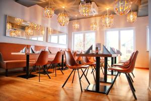 瓦尔多夫Walldorf Suites Boutique Hotel的餐厅设有桌椅和吊灯。
