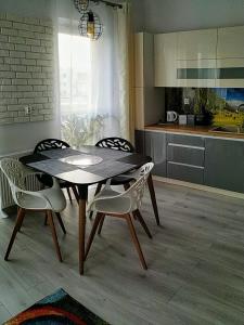 波兹南Apartament Przytulny Podolany的厨房里配有餐桌和椅子
