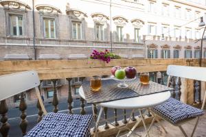 罗马Amazing Piazza Venezia Suites的阳台上的桌子上摆放着水果和饮料