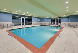 达拉斯Holiday Inn Express & Suites - Dallas NW HWY - Love Field, an IHG Hotel的蓝色的大游泳池,位于酒店客房内