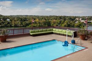奥斯汀奥斯汀甸镇湖假日酒店的一座位于酒店屋顶的游泳池,配有沙发