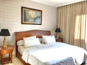 雅加达Ambassador Apartment Kuningan的卧室配有一张带白色床单和枕头的大床。