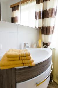 阿特湖畔施泰因巴赫Wohnung am See的浴室设有浴缸,上面有黄毛巾