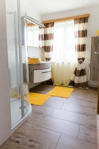 阿特湖畔施泰因巴赫Wohnung am See的带淋浴的浴室和黄色地毯