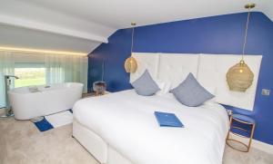 克利夫登Connemara Sands Hotel & Spa的卧室配有一张白色大床和浴缸