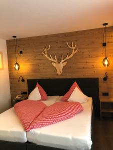 海特尔旺珀斯特汉莎膳食公寓酒店的卧室配有一张床铺,墙上挂着鹿角