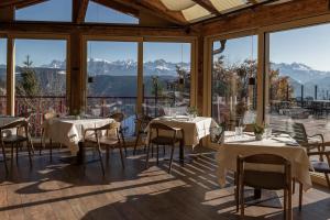 圣杰内肖阿泰西诺舍格尔伯格霍夫酒店的餐厅设有桌椅和大窗户。