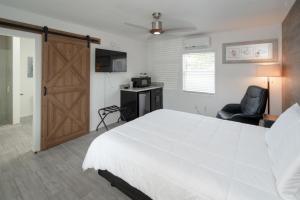 基拉戈Sun Outdoors Key Largo的卧室配有白色大床和推拉门。