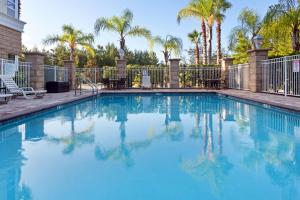 代托纳海滩德通纳海滩LPGA大道假日酒店的一个带围栏和棕榈树的游泳池