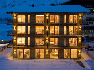 布勒伊-切尔维尼亚Red Fox Lodge的雪中的房子,晚上有灯