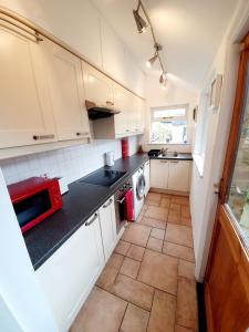 切姆Chelmsford Centre House的厨房配有白色橱柜和红色微波炉