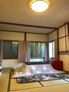 草津Oyado Zen的配有窗户的客房内的一张大床