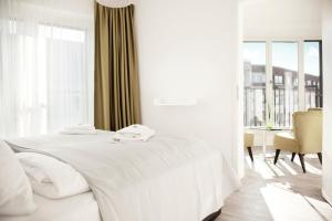 柏林罗森塔尔公寓式酒店的白色的卧室设有白色的床和窗户。