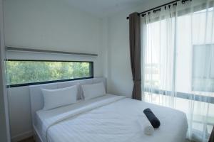 普吉镇Happy Family Villa的卧室配有白色的床和窗户