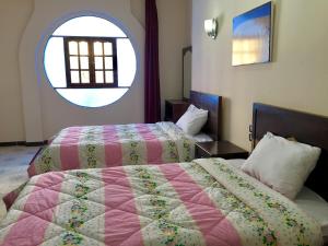 卢克索Sunflower Guest House Luxor West Bank的一间卧室设有两张床和大窗户