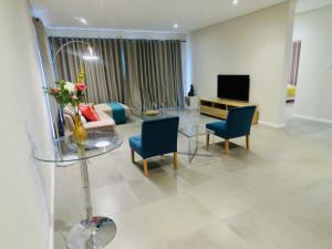 埃祖尔韦尼The Executive - Exclusive Self-Catering Apartments - Ezulwini的客厅配有桌椅和电视。