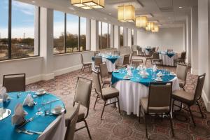 达拉斯Crowne Plaza Dallas Love Field - Med Area, an IHG Hotel的宴会厅配有蓝色的桌椅和窗户。
