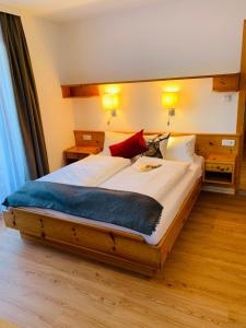 维尔芬翁Gasthof Schöntal的一间卧室配有一张大床,配有白色床单和红色枕头
