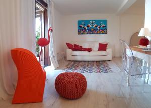 罗通多港Geco di Giada Art Suites - Adult Only的客厅配有白色沙发和红色椅子