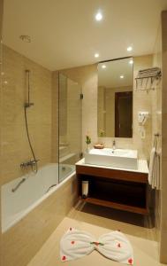 乌姆苏克Djerba Resort- Families and Couples Only的带浴缸、水槽和浴缸的浴室