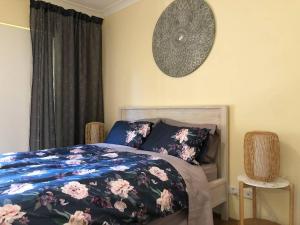 悉尼Escape to Strathfield for 8 guests的卧室配有一张床,墙上挂着一个钟