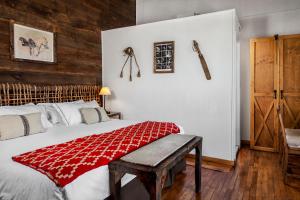 蓬塔阿雷纳斯拉耶瓜洛卡精品酒店的一间卧室配有一张床铺,床上铺有红色毯子