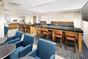 大学公园市大学公园智选假日套房酒店 - 大学区的一间会议室,配有蓝色椅子和长桌