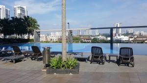 塞贝维Residence @ Shaftsbury Cyberjaya的一组椅子和桌子,位于游泳池旁