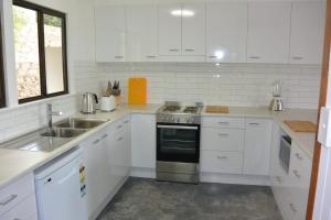 波因特卢考特Alicante的白色的厨房设有水槽和炉灶。