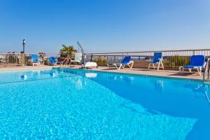 查尔斯顿查尔斯顿-河滨假日酒店的一个带蓝色椅子的大型游泳池