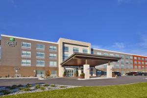 大急流城Holiday Inn Express & Suites Grand Rapids Airport North, an IHG Hotel的一张酒店大楼的图片,里面有一个停车场