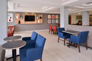 帕克斯堡矿泉井城智选假日酒店的一间设有蓝色桌椅和柜台的餐厅
