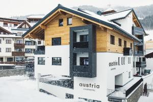 费斯Austria Aparthotel的冬天有雪的建筑