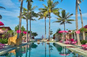 吉利阿尔PinkCoco Gili Air - Constant Surprises - for Cool Adults Only的棕榈树和粉红色椅子的度假村的游泳池