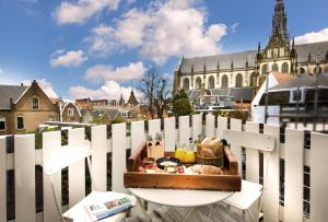 哈莱姆Haarlem Hotel Suites的盘子上盘的食品,放在白色的栅栏上
