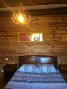 CharmesLe Maquis的一间卧室配有一张木墙床