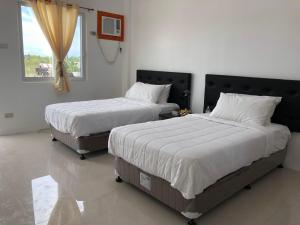 MayaArriyus Apartelle的卧室设有2张床和窗户。