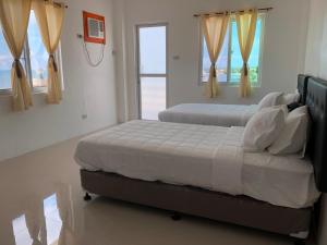 MayaArriyus Apartelle的卧室设有两张床,带两个窗户