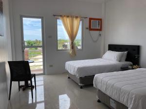 MayaArriyus Apartelle的酒店客房设有两张床和窗户。