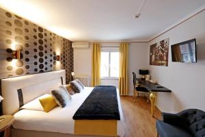 阿尔比Hotel Les Pasteliers的配有一张床和一张书桌的酒店客房