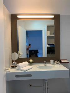 圣弗朗索瓦Le PARADIS BLEU VUE MER的浴室水槽和镜子,还有人拍照