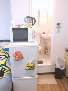 大阪林林の民宿-関空直達、minion room 小黄人主题房的厨房配有冰箱上方的微波炉