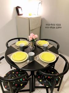武吉丁宜Bukit Tinggi 1 Hati guesthouse的一张黄色的黑桌,上面有鲜花