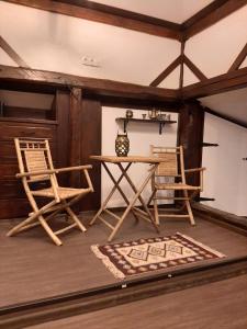多布里尼什特Relax Dobrinishte的一间设有两把椅子、一张桌子和一张桌子的房间