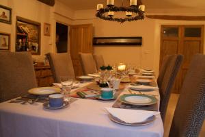 Aveton GiffordCourt Barton Farm的餐桌、白色桌布和椅子
