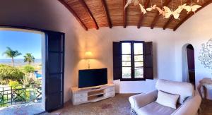 法鲁Monte Borboleta的客厅配有电视、椅子和窗户