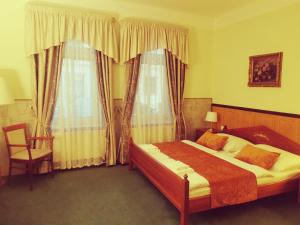 布拉格River Star Hotel的一间卧室配有一张床、一把椅子和窗户。
