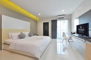 拉差汶里班拉姆恩酒店的一间卧室配有一张床和一台平面电视