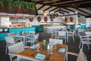 莫雷洛斯港El Beso Adults Only at Ocean Coral & Turquesa All Inclusive的一间带桌椅的餐厅和一间厨房